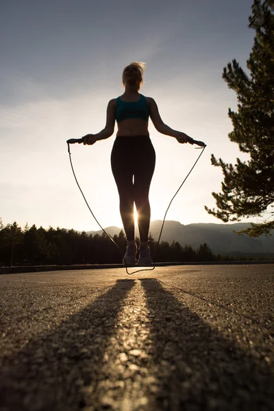 Deportiva mujer saltando en el paseo en un día soleado, tono retro —  Fotos de Stock