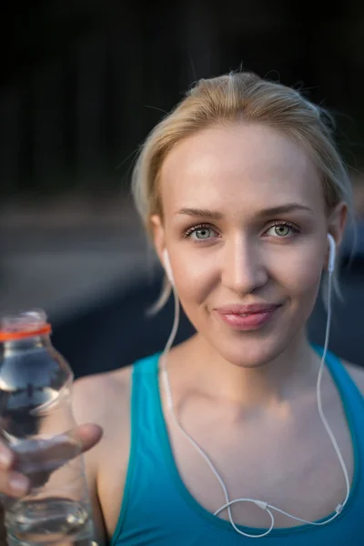 Вмістити блондинку пити з пляшки води в сонячний день — стокове фото