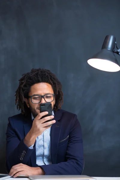 Πορτρέτο του ευτυχής έξυπνη μαύρο επιχειρηματία που κάθεται στο γραφείο σε μακριά — Φωτογραφία Αρχείου
