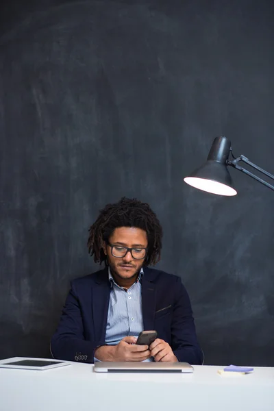 オフで机に座って幸せスマート黒ビジネスマンの肖像画 — ストック写真