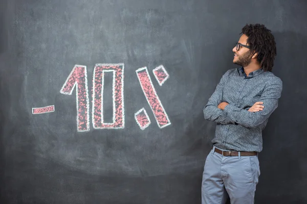 mixed race afro man standing in front of chalkboard with discoun