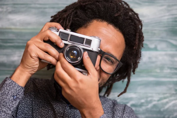 Happy hipster mannen leende med toy kamera på rustika backgorund — Stockfoto