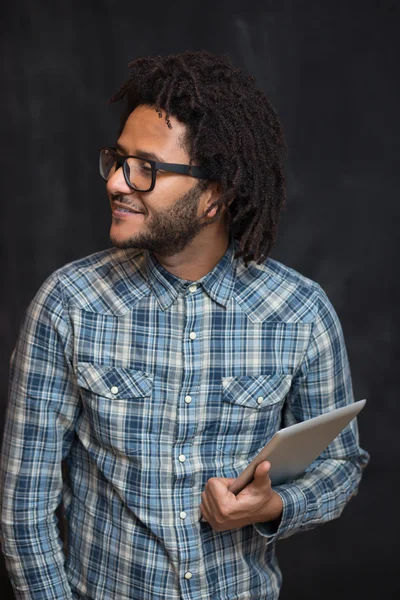 Enjoying his digital tablet. Cheerful young African man holding — Stock Photo, Image