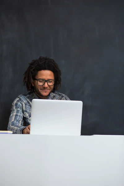 Portrait of happy smart black businessman sitting at desk in off — Stock Photo, Image