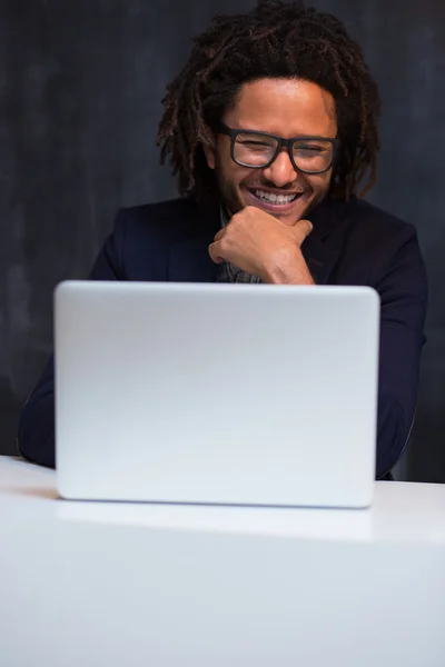 Portrait de heureux homme d'affaires noir intelligent assis au bureau dans off — Photo