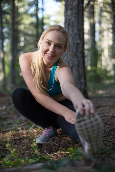 Mujer deportiva yong esparciendo su pierna en el parque de verano —  Fotos de Stock