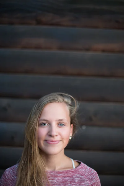 Modieuze vrouw poseren buitenshuis op houten achtergrond — Stockfoto