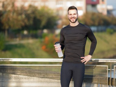 Genç adam plastik şişe ile koşu