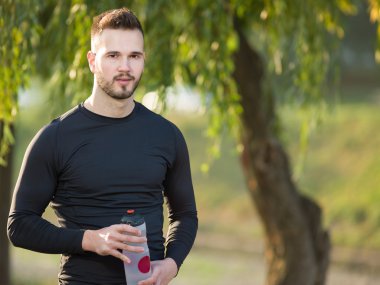 Genç adam plastik şişe ile koşu