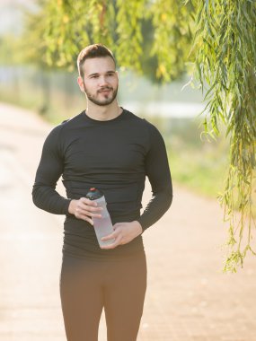 Genç adam plastik şişe ile koşu