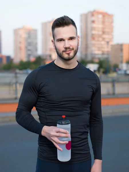 Muž pitné vody v městském parku — Stock fotografie