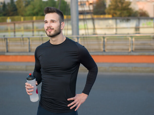 Man drinking water in urban park