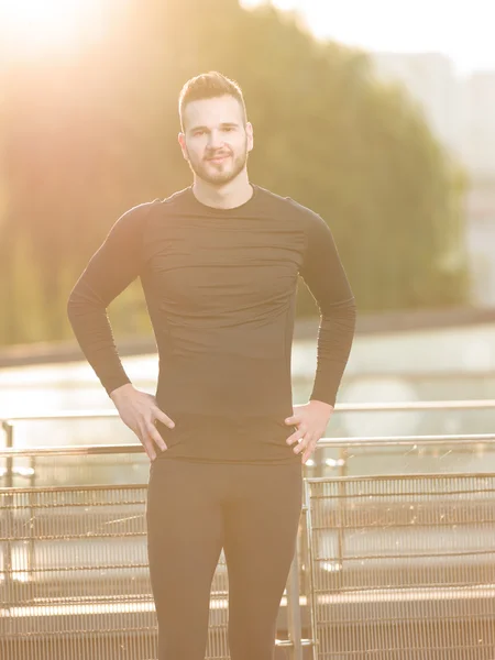 Atleta masculino seguro de pie con las manos en las caderas mirando un — Foto de Stock