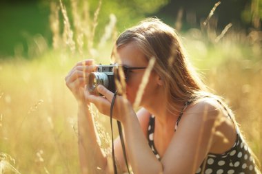 Vintage bir kamera tutan genç kadın fotoğrafçı.