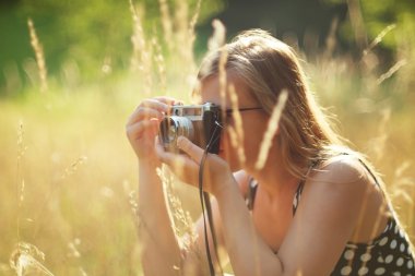 Vintage bir kamera tutan genç kadın fotoğrafçı.