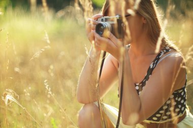 Vintage bir kamera tutan genç kadın fotoğrafçı.