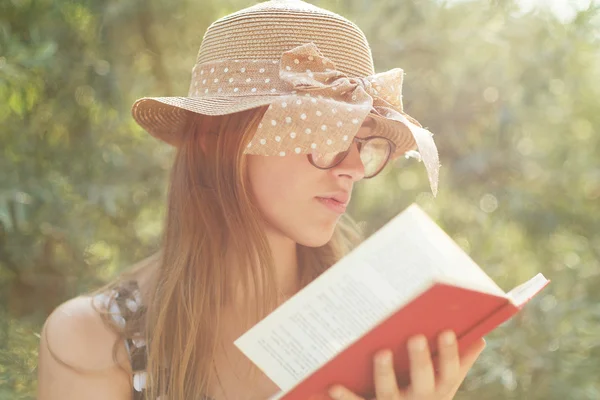 Bella ragazza di campagna che legge un libro in natura, godendo di sole — Foto Stock