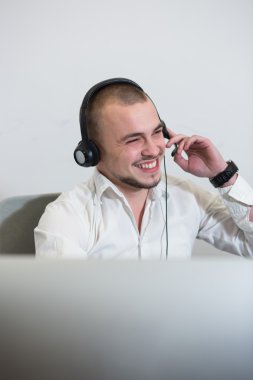 Casual genç adam bilgisayar kullanarak mezartaşı ile gülümseyen