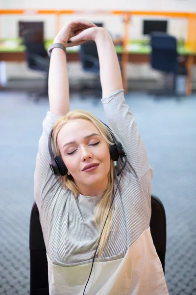 Young businesswoman stretching at desk