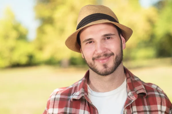 Happy hipster with hat looking at camera on a sunny day — Stock fotografie