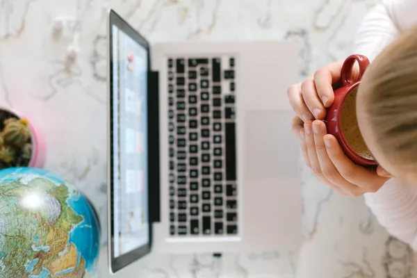 Mulher digitando em um computador e escrevendo uma nota — Fotografia de Stock