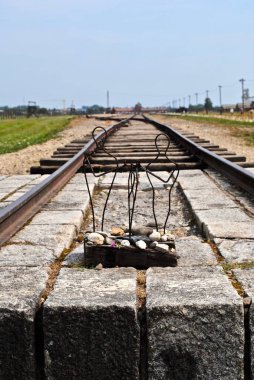 AUSCHWitz - Eski Nazi toplama kampı, BirkENAU. Demiryolu raylarının ucunda oturan küçük metal tel bir aile heykeli birçok aile ayrılmıştı ve yıkılmıştı..