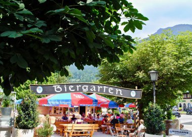 Berchtesgaden, Germany: A traditional German Biergarten (Beer Garden) in Bavaria. Umbrellas read 