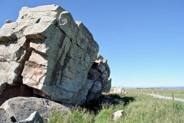 Büyük Kaya Dengesiz. Kanada, Alberta, Okotoks yakınlarındaki bu devasa ve alışılmadık kaya oluşumu dünyanın en büyük düzensiz buzuludur. Buzul çağından kalma büyük kaya parçaları düz zemine bırakılmış.. 