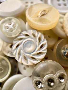 White, off-white and cream antique or vintage sewing buttons: Celluloid Buttons, Bakelite Buttons, Lucite Buttons, Vegetable Ivory, metal, China, glass, and mother of pearl.  clipart