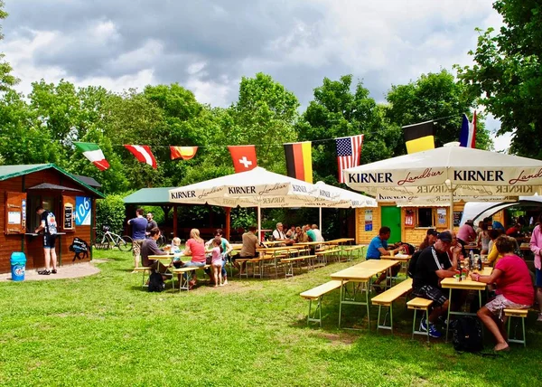 Bad Sobernheim, Almanya: Çıplak ayak parkı (Barfupfad) yakınlarındaki tipik Alman bira bahçesi (Biergarten), uluslararası bayraklar ve yerel bira reklamları ile. 