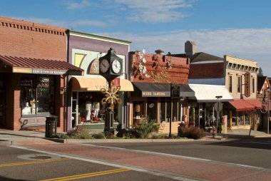 Grass Valley, California, USA: Main Street with a clock tower, Clock Tower Records, Sierra Star Winery, and Pete's Pizza. Grass Valley is a Gold Rush town in the Sierra Nevada foothills. clipart
