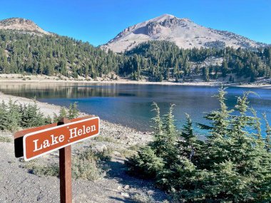 Lassen Volcanic National Park, California. Lake Helen with sign. Lassen peak is a cinder cone volcano. The Vulcans Eye is the rock formation  at the beginning of the Lassen Trail. clipart