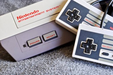 Nintendo Entertainment System (NES), Nintendo tarafından üretilen 8-bit üçüncü nesil ev oyunu konsolu. NES Denetim Güvertesi ev oyun konsolu denetleyiciler ile.