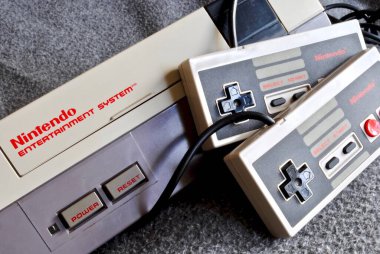 Nintendo Entertainment System (NES), Nintendo tarafından üretilen 8-bit üçüncü nesil ev oyunu konsolu. NES Denetim Güvertesi ev oyun konsolu denetleyiciler ile.