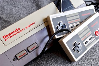 Nintendo Entertainment System (NES), Nintendo tarafından üretilen 8-bit üçüncü nesil ev oyunu konsolu. NES Denetim Güvertesi ev oyun konsolu denetleyiciler ile.