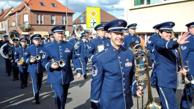 Ramstein, Almanya: Büyüleyici Hava Kuvvetleri askeri bandosu. Pirinç enstrüman taşıyan grup üyeleri geçit törenini izleyenlere gülümseyip el sallıyor..  