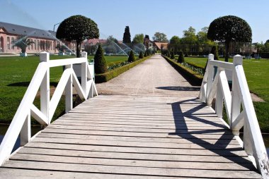 Schwetzingen, Almanya: Schloss Schwetzingen, Almanya 'nın Baden-Wrttemberg eyaletinde yer alan bir şehirdir. Resmi saray bahçesindeki köprü. Boxwood çitleri ve portakallara yakın manikürlü ağaçlar.. 