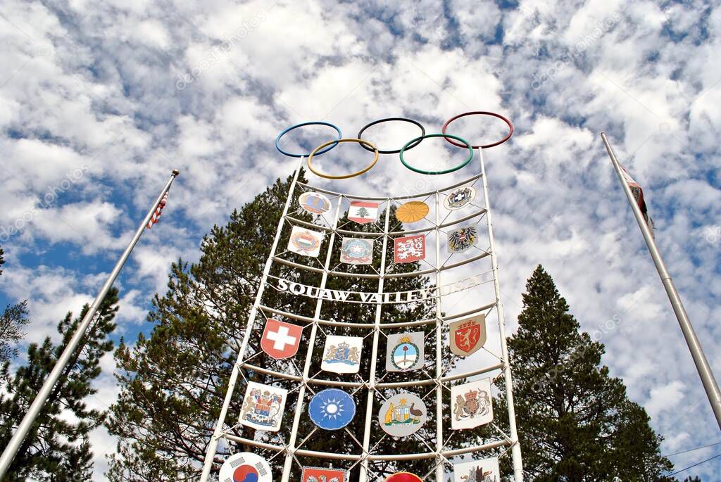 Olympic Valley, California: Olympic flame, international flags, and Olympic rings on signage for Squaw Valley Ski Resort in Olympic Valley, California. The host site of the 1960 Winter Olympics.