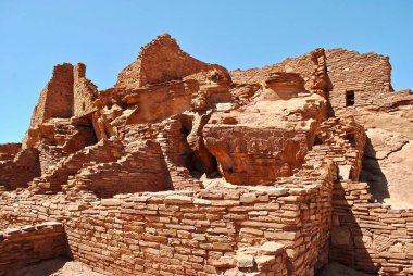 Wupatki Ulusal Anıtı ve Wupatki (uzun ev) pueblo. Konutun duvarları yerel Moenkopi kumtaşının ince düz bloklarından inşa edildi ve pueblolara belirgin kırmızı rengini verdi..