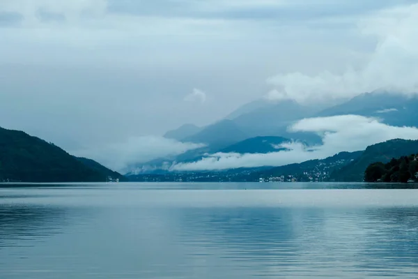 ミルスタテツェ湖のパノラマビューは オーストリアの海岸から 湖は高いアルプスに囲まれています 湖の穏やかな表面 自然の美しさ 厚い雲と暗い雲の上 静けさと静けさ — ストック写真