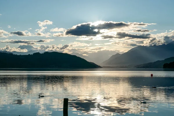 オーストリアのMillstetter湖で日没 湖は高いアルプスに囲まれています 陽射しを反射して湖の穏やかな表面 太陽が山の後ろに沈む 少し曇っている 自然の美しさ — ストック写真