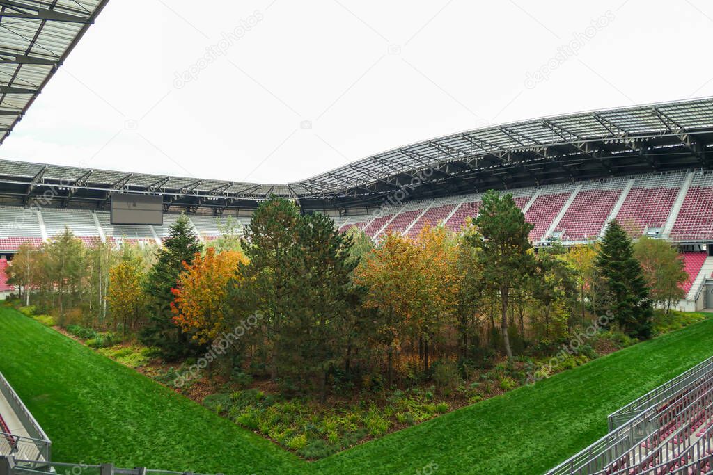 A forest planted in the middle of the football stadium in Klagenfurt, Austria. The pitch turf resembles the forest, changing colors for autumn. Many different tree sorts. Modern installation. Nature