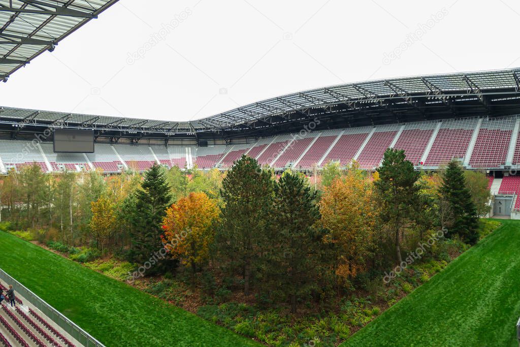 A forest planted in the middle of the football stadium in Klagenfurt, Austria. The pitch turf resembles the forest, changing colors for autumn. Many different tree sorts. Modern installation. Nature