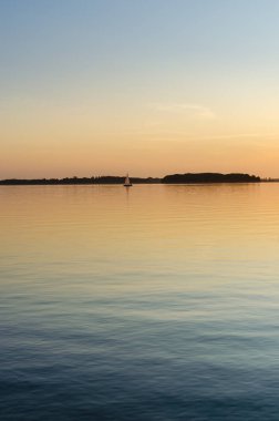 Masurian Gölü, motorlu tekne ve uzaktaki yatlar. Güneşli bir gün. İnsanlar yatta dinleniyor. 14 Eylül 2020 Mazry, Swiecajty Gölü, Polonya