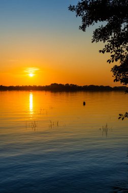 Masurian Gölü, motorlu tekne ve uzaktaki yatlar. Güneşli bir gün. İnsanlar yatta dinleniyor. 14 Eylül 2020 Mazry, Swiecajty Gölü, Polonya