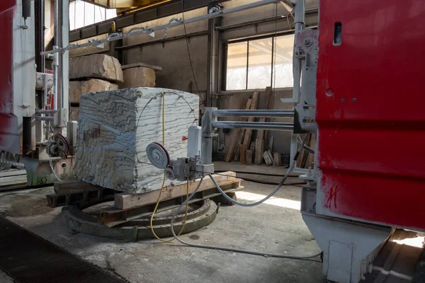 Stone wire saw. Machine for cutting granite stones. Cutting granite in a stonemason's workshop. Cutting an oval in stone. Single Wiresaws