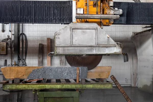 Machine for cutting granite stones. Cutting granite in a stonemason\'s workshop.