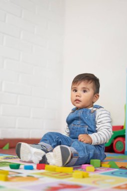 Bebek bahçe kıyafetleriyle evde oynuyor.