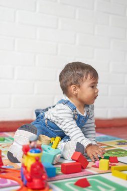 Bebek bahçe kıyafetleriyle evde oynuyor.