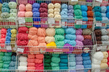 Çok renkli örgü iplikleri raflardaki konteynırlara konur.